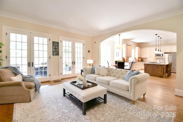 5827 Rileys Ridge Rd, Charlotte, NC 28226 - living room with french doors, arched walkways, crown molding, and light wood finished floors
