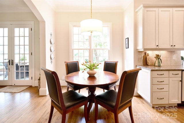 5827 Rileys Ridge Rd, Charlotte, NC 28226 - dining area with light wood-style flooring, french doors, crown molding, and arched walkways