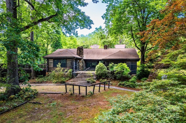 rear view of house with a chimney and log exterior