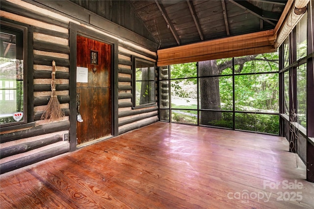 unfurnished sunroom featuring vaulted ceiling