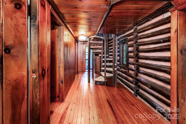 wine area with hardwood / wood-style floors, wooden ceiling, and wooden walls