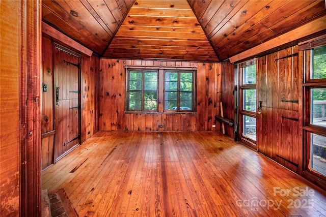 spare room featuring lofted ceiling, hardwood / wood-style floors, wood walls, and wood ceiling