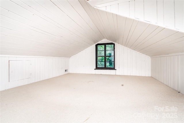 bonus room featuring carpet floors, vaulted ceiling, and wood walls