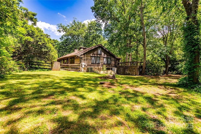 back of property featuring log siding, a chimney, and central air condition unit