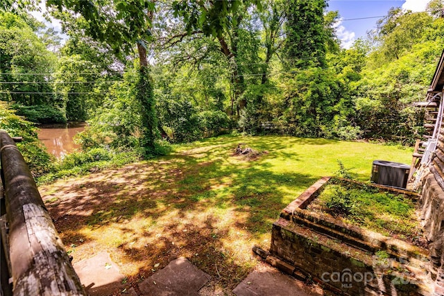 view of green lawn with cooling unit
