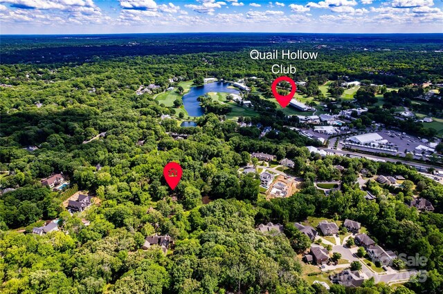 aerial overview of property's location with a forest, a large body of water, and nearby suburban area