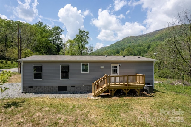 back of house featuring central AC unit, a deck with mountain view, a yard, and crawl space