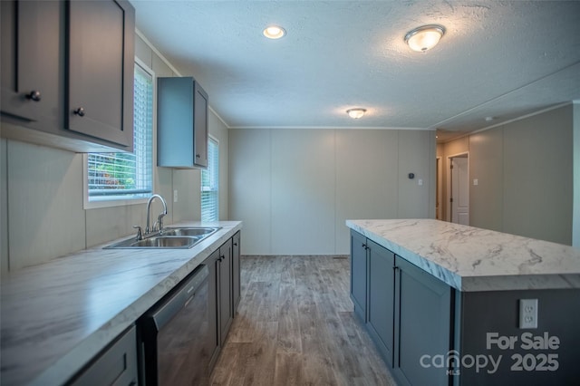 kitchen featuring light countertops, a sink, light wood-style flooring, and dishwasher
