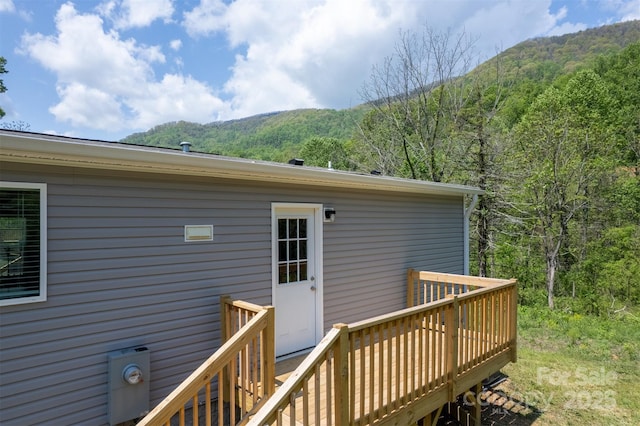 wooden deck with a mountain view and a wooded view