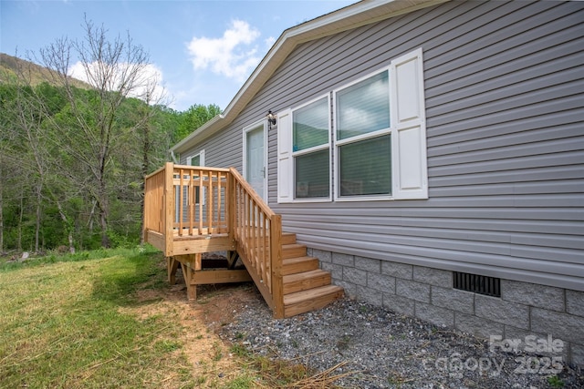 view of property exterior with a deck and crawl space
