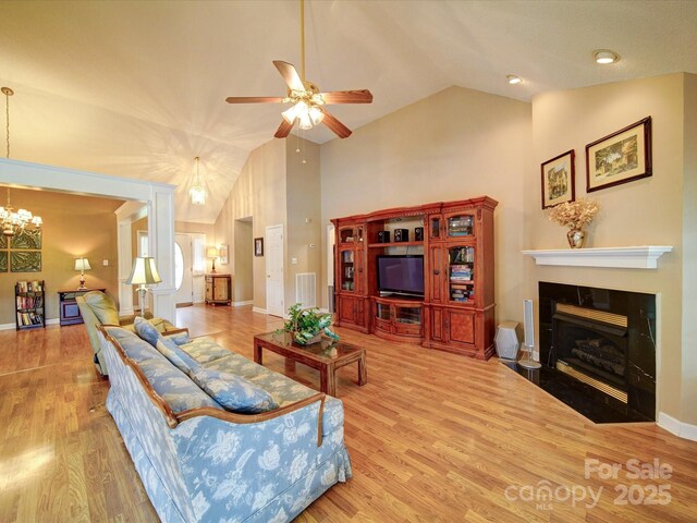 2547 Bill Thompson Rd, Lancaster, SC 29720 - living area featuring wood finished floors, ceiling fan, a chandelier, a fireplace with flush hearth, and baseboards