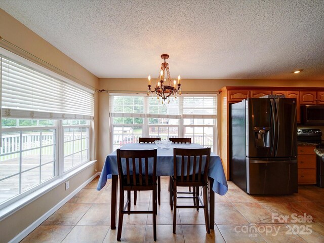 2547 Bill Thompson Rd, Lancaster, SC 29720 - dining area featuring a chandelier, a textured ceiling, light tile patterned floors, and baseboards