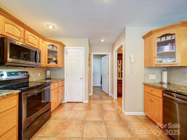2547 Bill Thompson Rd, Lancaster, SC 29720 - kitchen featuring stainless steel appliances, light stone countertops, backsplash, glass insert cabinets, and recessed lighting