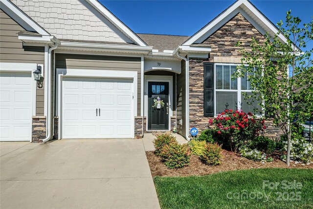 70 Cameo Dr, Flat Rock, NC 28731 - view of front of property featuring stone siding, concrete driveway, and a garage