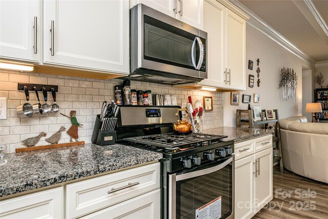 70 Cameo Dr, Flat Rock, NC 28731 - kitchen featuring appliances with stainless steel finishes, ornamental molding, open floor plan, wood finished floors, and dark stone countertops