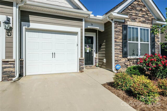 70 Cameo Dr, Flat Rock, NC 28731 - doorway to property with stone siding, concrete driveway, and a garage