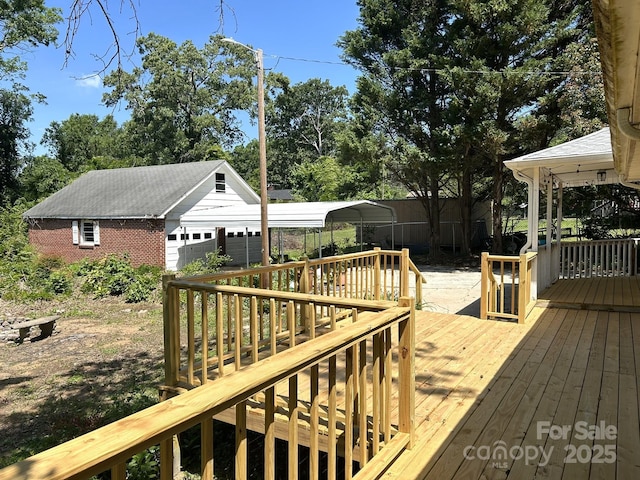 deck with a detached garage, fence, and an outbuilding