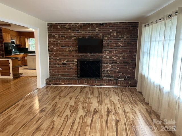 unfurnished living room with light wood finished floors and a fireplace