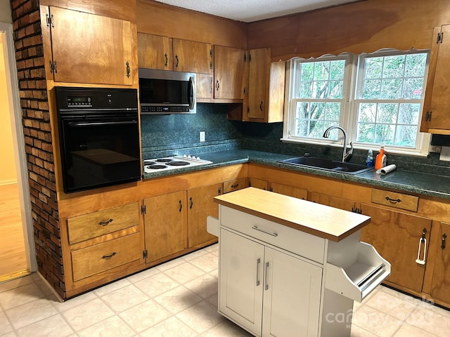 kitchen with oven, stainless steel microwave, a sink, white electric stovetop, and brown cabinets