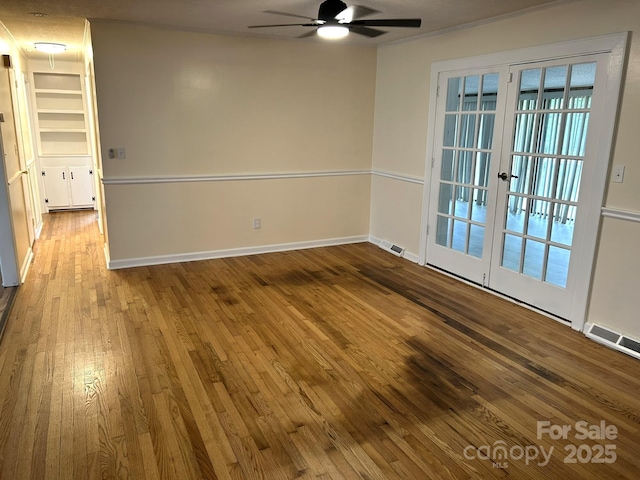 spare room with ceiling fan, wood-type flooring, french doors, and baseboards