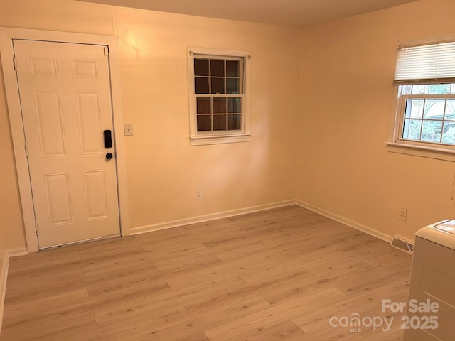 unfurnished room with light wood-style flooring and baseboards