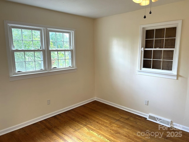 empty room with baseboards and wood finished floors
