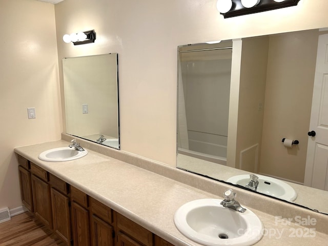bathroom featuring double vanity and wood finished floors