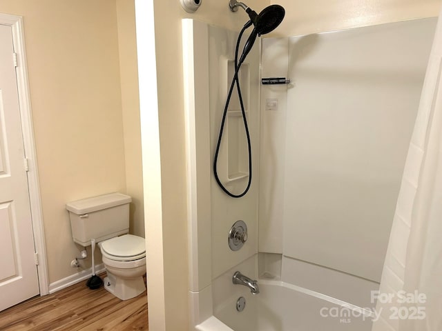 full bath featuring toilet, wood finished floors, and shower / tub combo with curtain