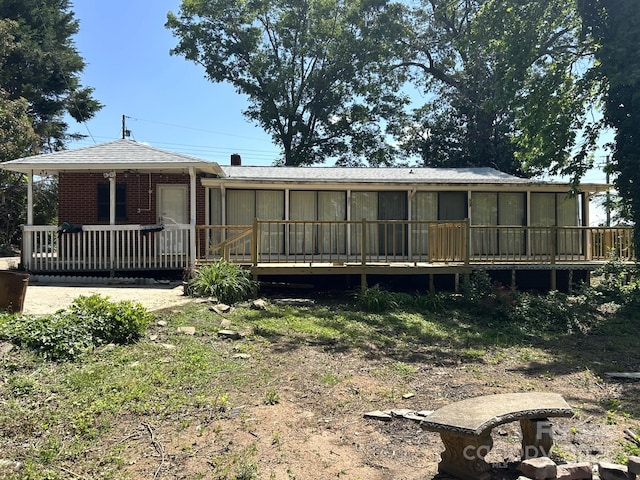 rear view of house with a sunroom and brick siding