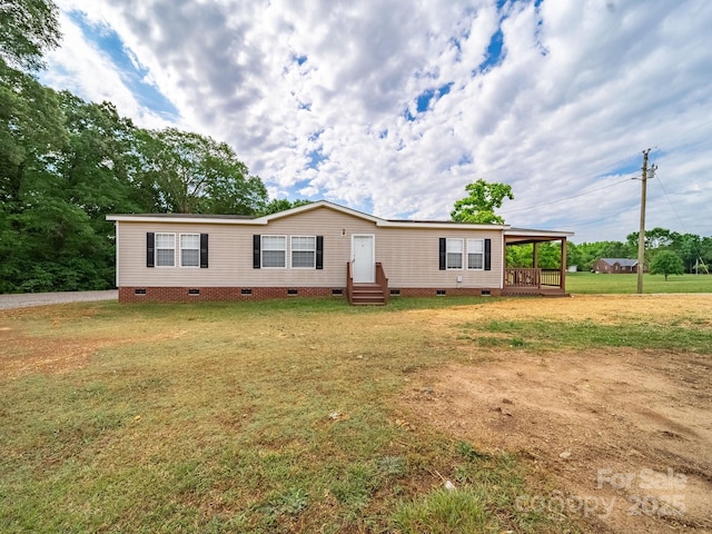 manufactured / mobile home featuring a front yard, entry steps, and crawl space