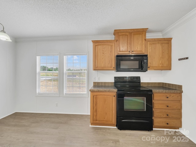 kitchen featuring a textured ceiling, black appliances, crown molding, light wood finished floors, and dark countertops