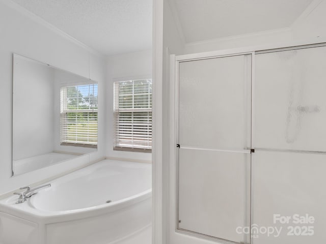 full bath with crown molding, a textured ceiling, and a bath