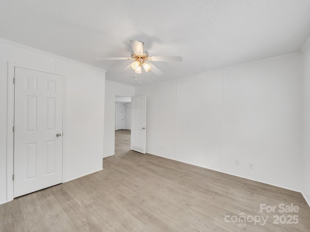 unfurnished bedroom featuring crown molding, a textured ceiling, ceiling fan, and wood finished floors
