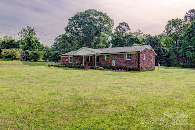 ranch-style home featuring brick siding, a front lawn, and a chimney