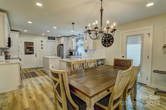 dining area featuring an inviting chandelier, recessed lighting, and light wood finished floors