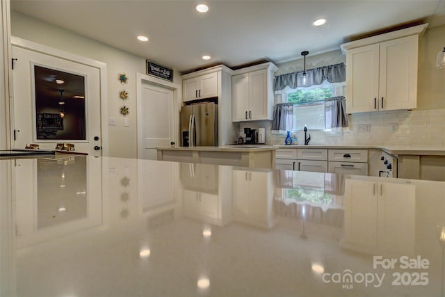 kitchen with stainless steel fridge, recessed lighting, white cabinetry, and tasteful backsplash