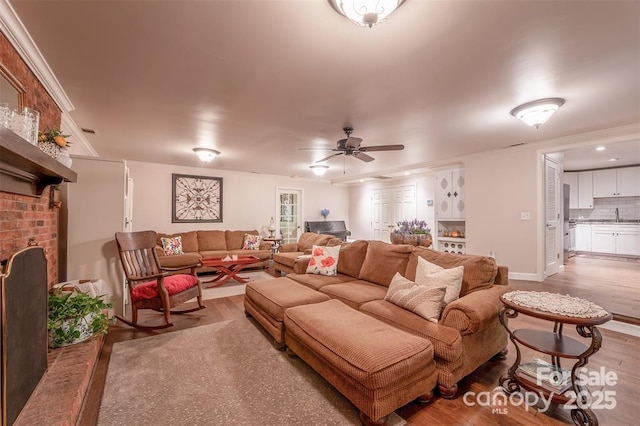 4805 Nesbit Rd, Monroe, NC 28112 - living area with crown molding, ceiling fan, a brick fireplace, and wood finished floors