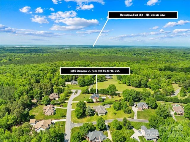 birds eye view of property with a wooded view and a residential view