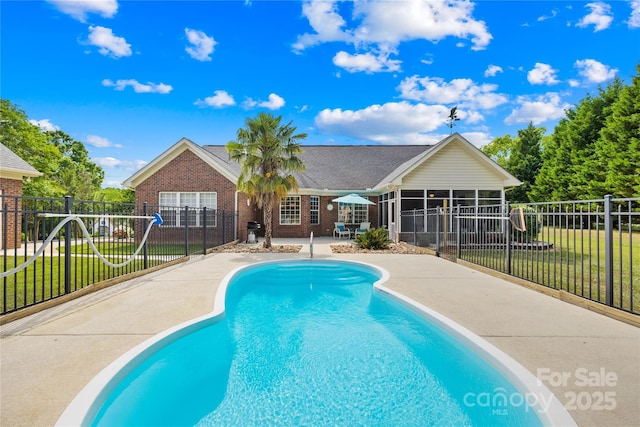 view of swimming pool with a sunroom and a patio area