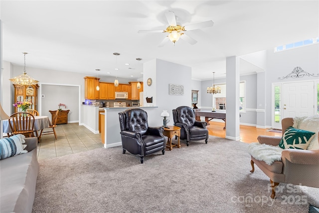 living area with a chandelier, light colored carpet, a ceiling fan, baseboards, and recessed lighting
