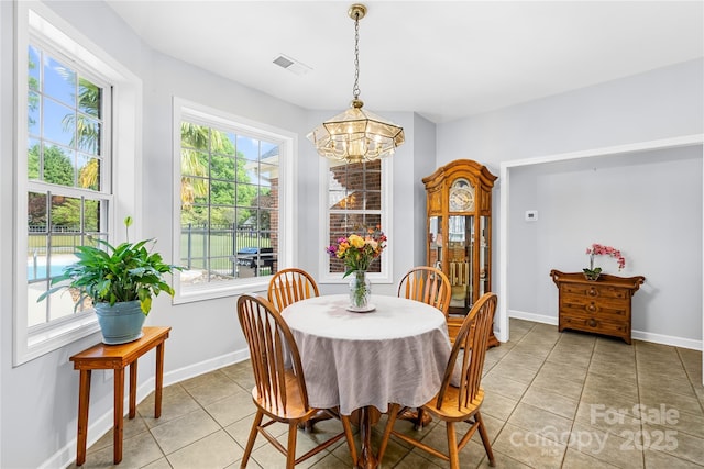 dining room featuring a chandelier, light tile patterned floors, healthy amount of natural light, and baseboards