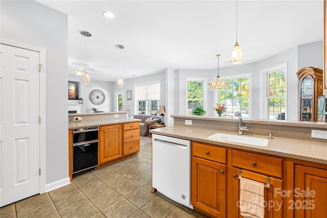 kitchen featuring light countertops, plenty of natural light, a sink, and dishwasher