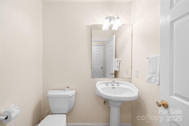 half bath featuring toilet and a sink