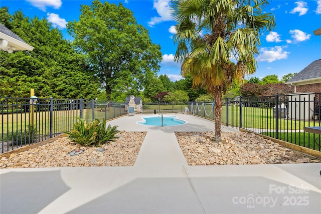 view of swimming pool with a yard, a patio area, a fenced in pool, and fence