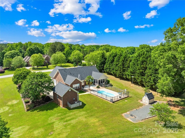 view of subject property featuring a pool area and a forest