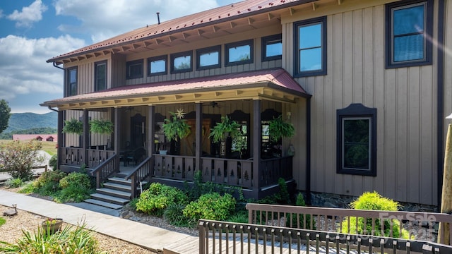 view of front of home with covered porch, a mountain view, and metal roof