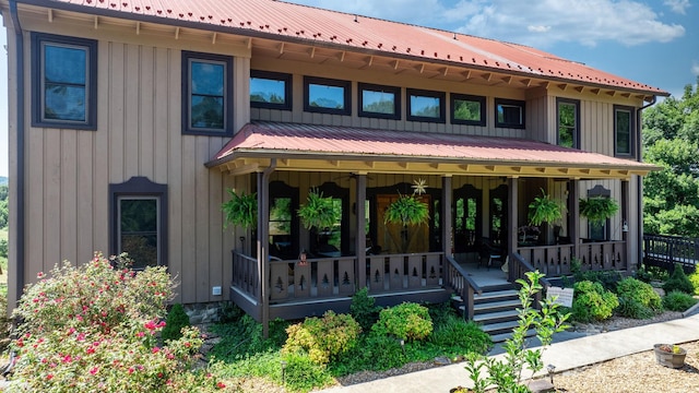 back of house featuring covered porch and metal roof