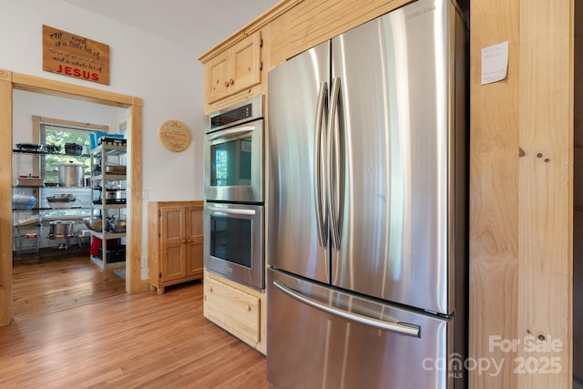 kitchen featuring stainless steel appliances, light wood-type flooring, and light brown cabinets