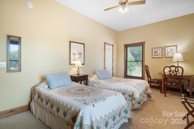 bedroom featuring a ceiling fan, baseboards, light colored carpet, and multiple windows