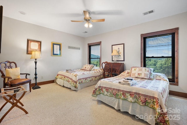 carpeted bedroom with a ceiling fan, baseboards, and visible vents